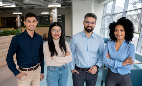 Four Community Solutions team members standing together and smiling in an office